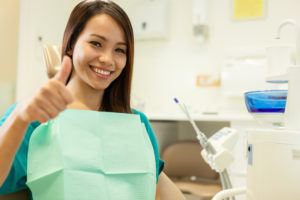 woman thumbs up dental chair