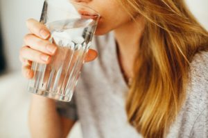 Woman drinking a glass of water at holistic dentist in Southlake.