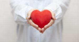 Holistic dentist in Southlake holding a heart.