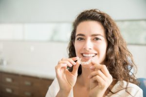 Woman holding clear aligners in Southlake. 