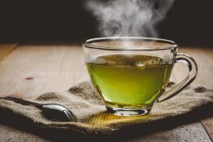 Close-up of hot cup of green tea on tabletop