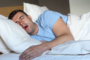 Man snoring in bed, possibly suffering from sleep apnea