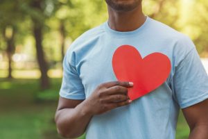 Man holding heart-shaped cutout over his chest