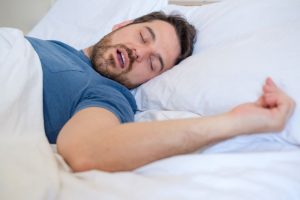 Man sleeping in bed, snoring