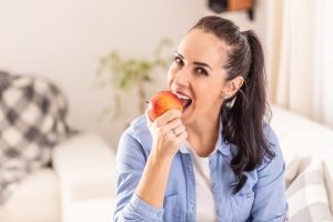 Happy woman biting into an apple