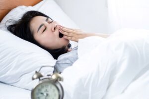 Woman lying in bed, yawning