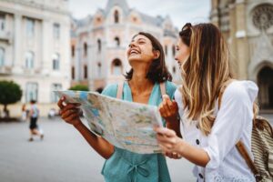 Two friends looking at a map while on vacation 