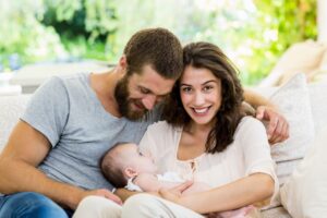 Mother and father cuddling with their child 